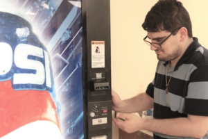 Individual standing next to vending machine.
